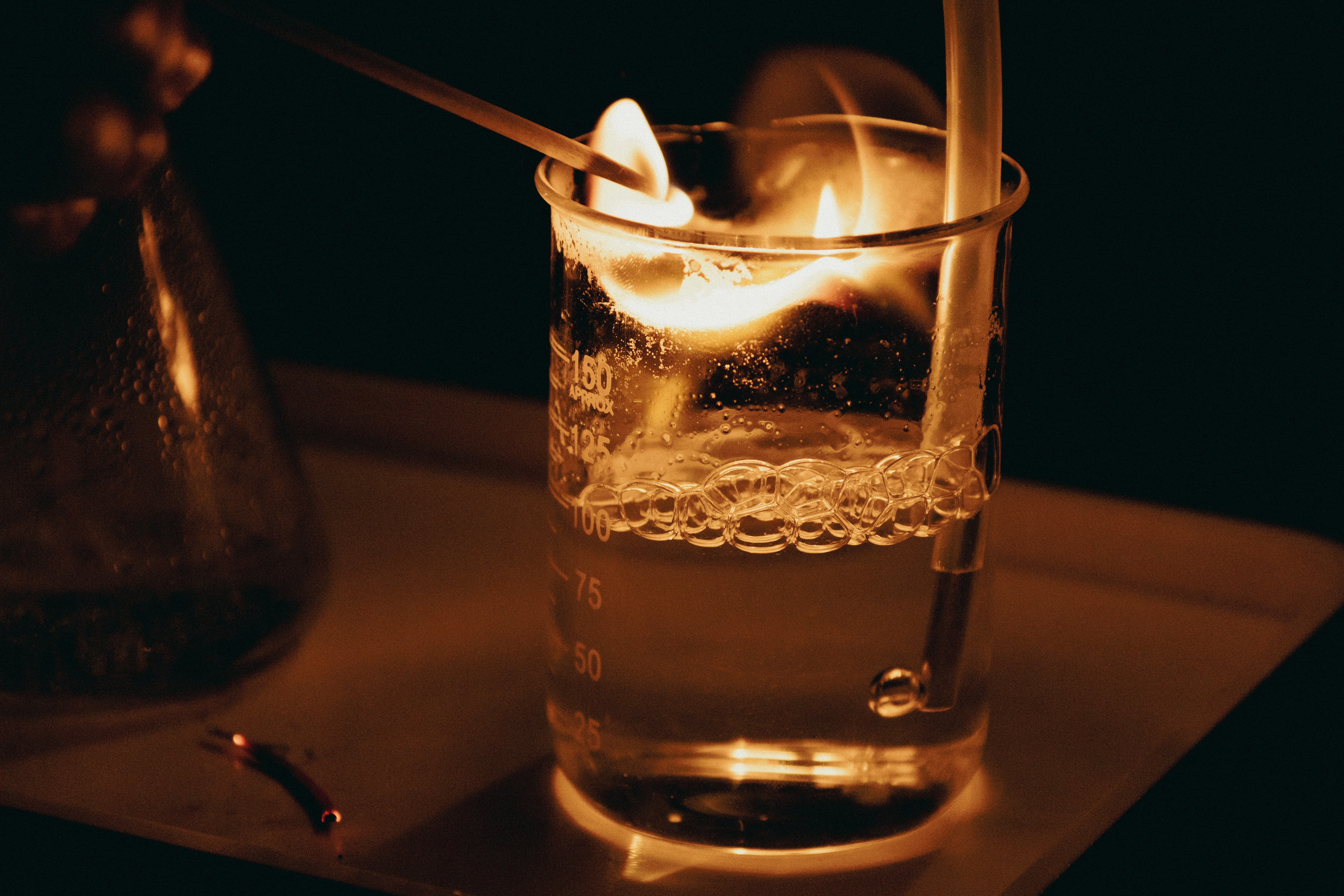 A chemistry experiment glowing inside a glass beaker